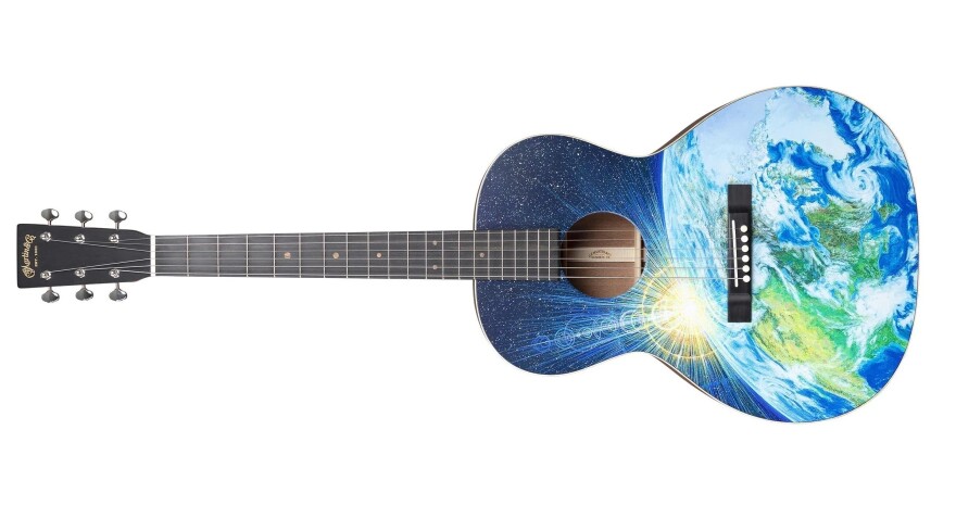 A guitar with the sun rising over Earth as viewed from space depicted on the body.