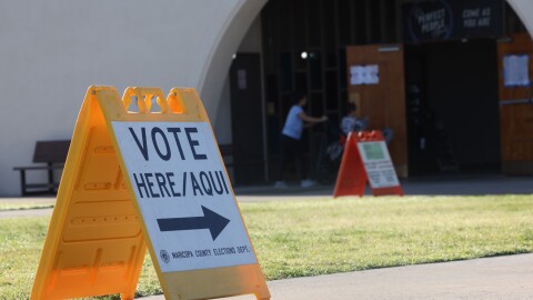 Yellow voter here sign in front of building