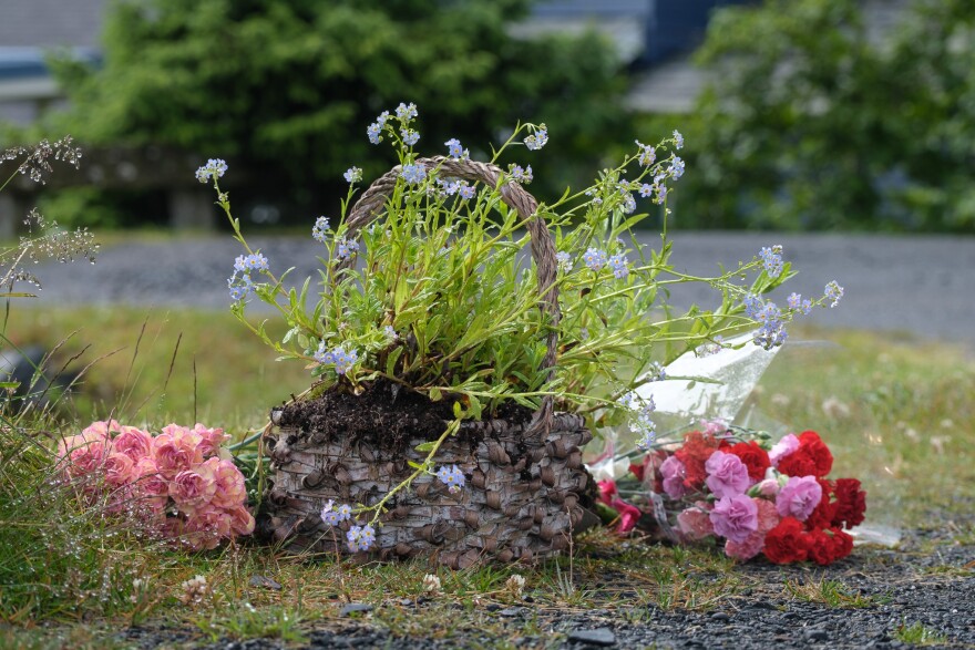 Some folks left flowers near this basket, a bit further from the road, July 17, 2023. (Brian Venua/KMXT)
