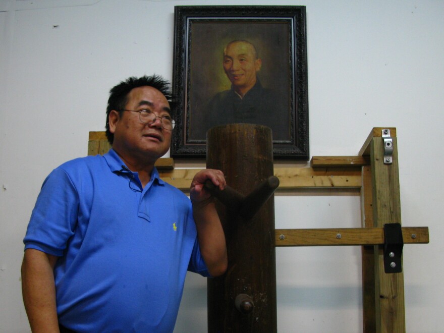 Allan Lee, 64, at his kung fu studio in Queens, N.Y. Lee began studying Wing Chun-style kung fu under Ip Man (seen in portrait) and his disciples almost 50 years ago.