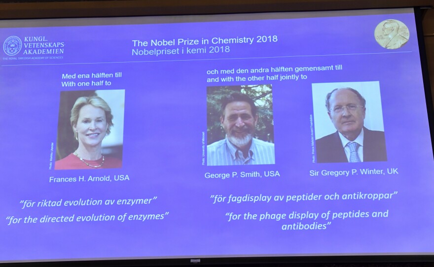 A screen displays portraits of Frances Arnold of the United States, George Smith of the United States and Gregory Winter of the U.K. during the announcement of the winners of the 2018 Nobel Prize in chemistry at the Royal Swedish Academy of Sciences on Wednesday.