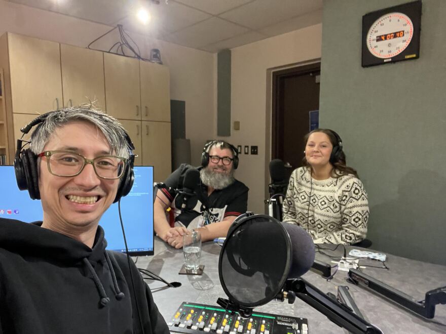 Three people take a selfie in a radio studio. 
