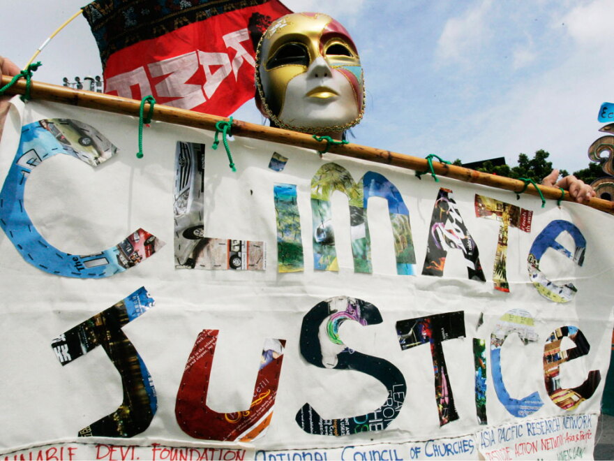 Masked activists hold banners during a protest Oct. 2 outside the U.N. regional office in Bangkok, where delegates held talks on climate change.