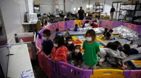 Young unaccompanied migrants ages 3 to 9 watch TV inside a playpen at the Donna Department of Homeland Security holding facility, the main detention center for unaccompanied children in the Rio Grande Valley in Donna, Texas, on March 30, 2021. (Dario Lopez-Mills/POOL/AFP via Getty Images)
