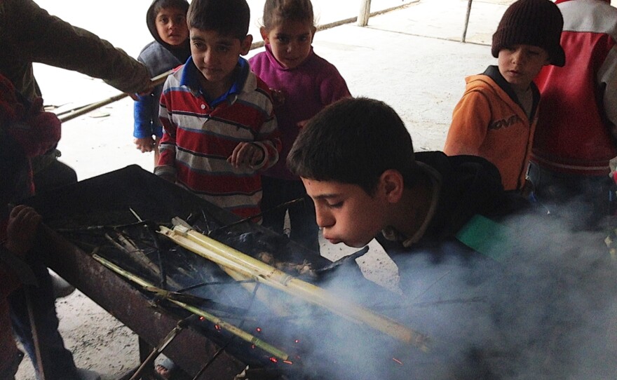 Syrian refugee children at the camp near Saida try to make a fire to keep warm, but the damp brush produces more smoke than heat. Most have no access to school and are forced to spend their days in the camp.