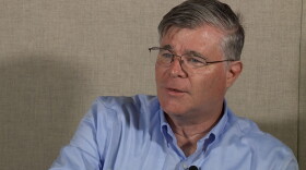 A man sits in a room looking off camera