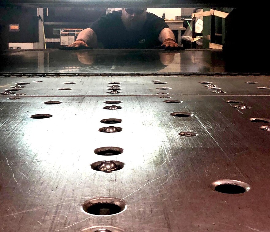 An employee with Vintec Manufacturing creates a camera mount, using a laser cutter at the Robert C. Byrd Institute in Huntington, West Virgnia.. The company, which used to primarily work with the coal mining industry, is pivoting to now sell outdoor cameras.