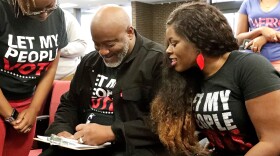 In this Jan. 8, 2019 file photo, former felon Desmond Meade and president of the Florida Rights Restoration Coalition, left, fills out a voter registration form as his wife Sheena looks on at the Supervisor of Elections office in Orlando, Fla.