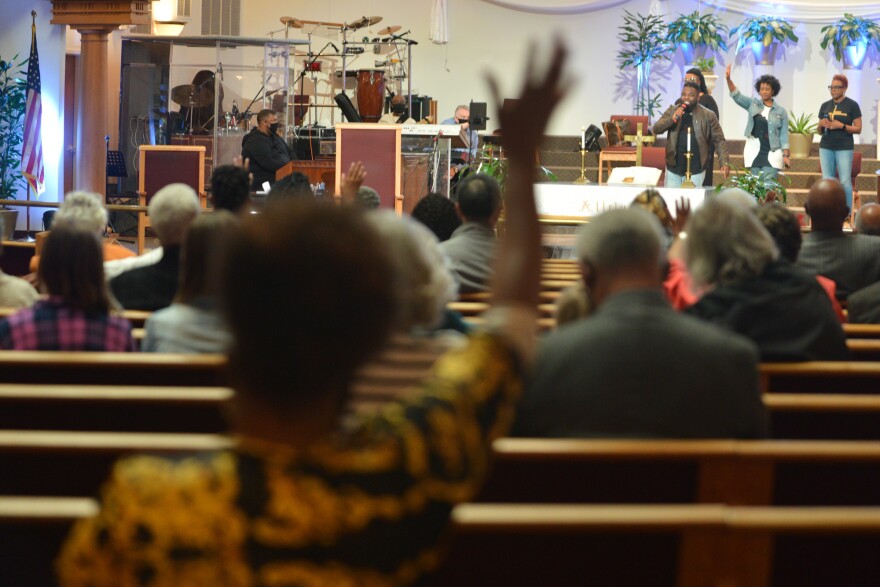 A quartet of singers takes the place of a choir at a physically distanced St. James United Methodist Church service.