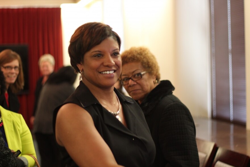 A woman in a black sleeveless shirt smiles past the camera.