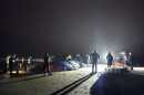 People stand around a stranded whale on a beach in the early morning in Oregon