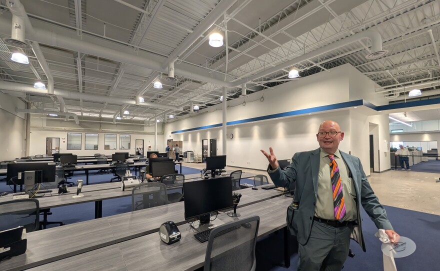 Summit County Board of Elections Deputy Director Pete Zeigler gestures to a workspace at the board's new location. 