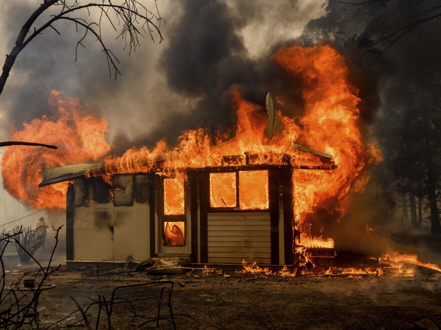 Flames from the Morton Fire consume a home near Bundanoon, New South Wales, Australia, on Thursday.