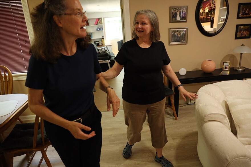 Patty Starr, at right, is deafblind. In this photo, she holds the arm of interpreter Elisa Mlynar as the two walk in Starr's home.