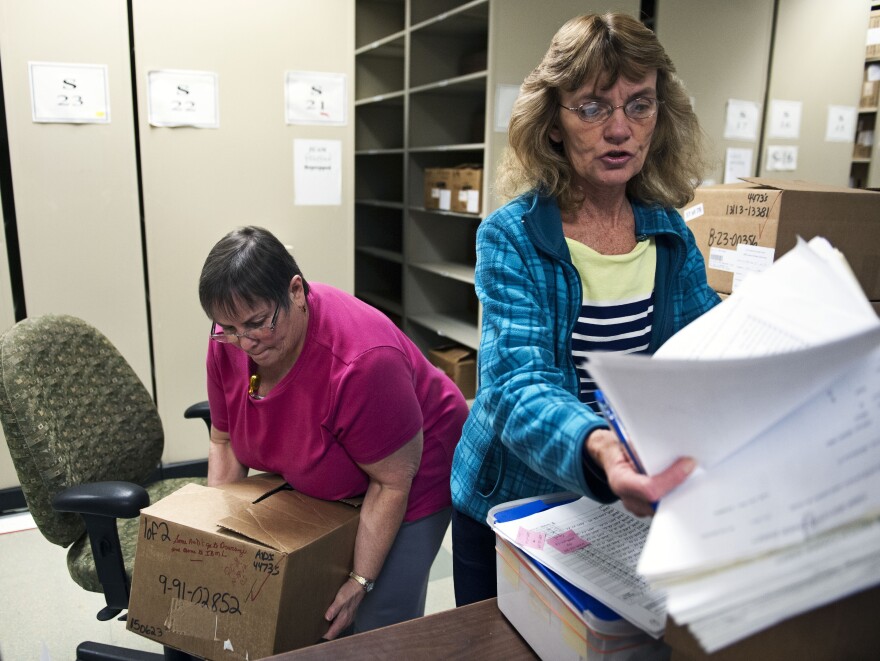 Document prep technician Carol Sine (left) and tracer Debra Barrett process firearm transaction documents at the National Tracing Center in Martinsburg, W.Va.