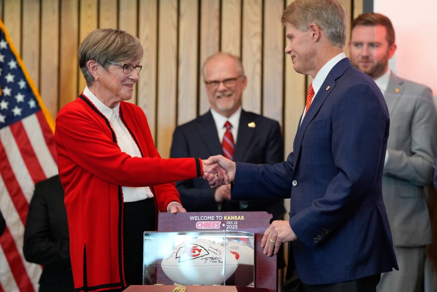 Kansas City Chiefs owner Clark Hunt, right, and Kansas Gov. Laura Kelly, shake hands during an event Monday, Dec. 22, 2025 in Topeka, Kansas, announcing the team will leave Arrowhead Stadium in Kansas City, Missouri, for a new stadium that will be built across the Kansas-Missouri state line.