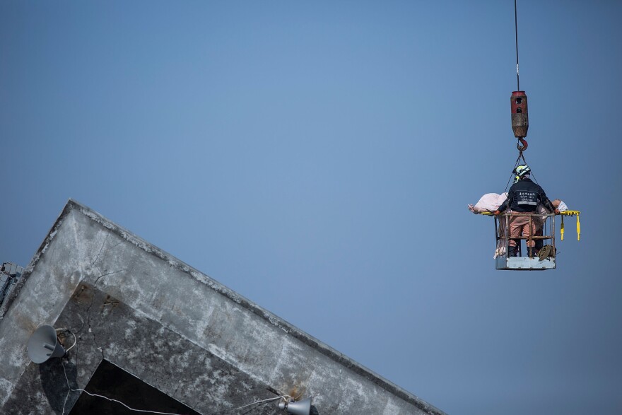 A survivor transported by rescue workers from a collapsed building.