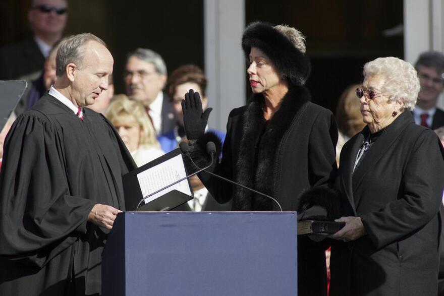 FILE - North Carolina State Auditor Beth Wood, center, is sworn into office by Supreme Court Justice Paul Newby as her mother Betty Wood looks on during North Carolina inaugural ceremonies on Jan. 10, 2009, at the State Library building in Raleigh, N.C. Beth Wood has a court date on Jan. 26, 2023, after she was cited for misdemeanor hit-and-run and another traffic-related charge when police said she hit a parked car while driving on a Raleigh road.