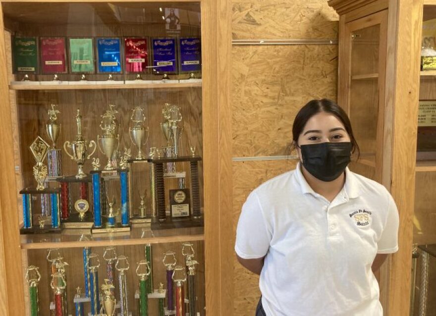 Santa Fe South senior Allison Bonilla stands in front of a trophy case at her high school. Bonilla said she was vaccinated against COVID-19, but before a masking requirement went into effect, she was one of the few students who actually wore a mask to school at SFS.