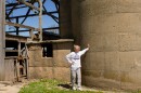 Marianne May poses at one of Frank May’s silos in Johnsburg, Illinois, on April 25, 2026. This one is particularly special to Marianne; her grandfather constructed it as an adult on the homestead he grew up on. Across the street, a matching silo stands besides Marianne May’s grandmother’s childhood home. Her grandparents were neighbors as kids.