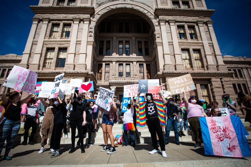 Demonstrators rally Tuesday against the attorney general's opinion stating some health care for trans children should be considered child abuse. 