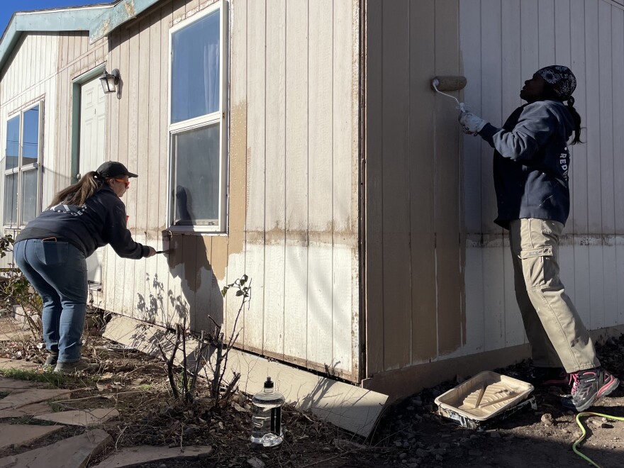 Greater Albuquerque Habitat for Humanity Construction Repair Supervisor Heather Cunningham and volunteer Felicia Brewster paint an older adult's home in Albuquerque.