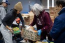 Volunteers Brooke Marshall, left, and Gwynn Beeler, center, help load up groceries for an attendee of the Central Texas Food Bank food distribution on Tuesday, Nov. 11, 2025, at George Morales Dove Springs Recreation Center in Austin. Food bank staff reported a 50% surge in demand at food distributions as SNAP benefits are cut. Michael Minasi / KUT News