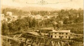 Old sepia-colored photograph of railway bridge outside an old town