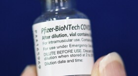 A nurse holds a vial containing the Pfizer-BioNTech COVID-19 vaccine at a mobile vaccination site.