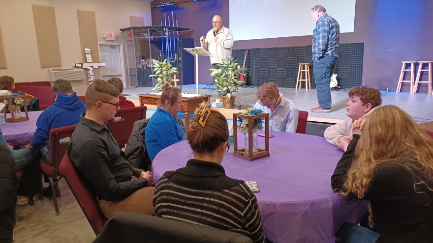 Reverend Troy Renter of Harlan prays with the assembly for a group of Perry Middle and High School students