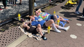 A woman and two kids wear eclipse glasses while watching the event on the Evansville riverfront, Mon. April 8