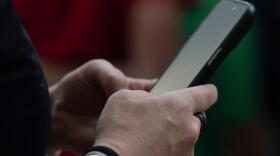 A person looks at their phone at Seattle–Tacoma International Airport on Sunday, June 1, 2025, in Seattle. (Jenny Kane/AP)