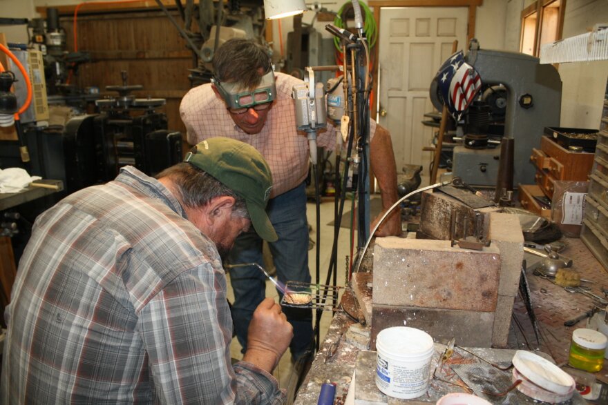 As part of an apprenticeship program, Jock Brown is learning how to silver solder, a process by which silver chips are heated and when melted join together two pieces of metal.