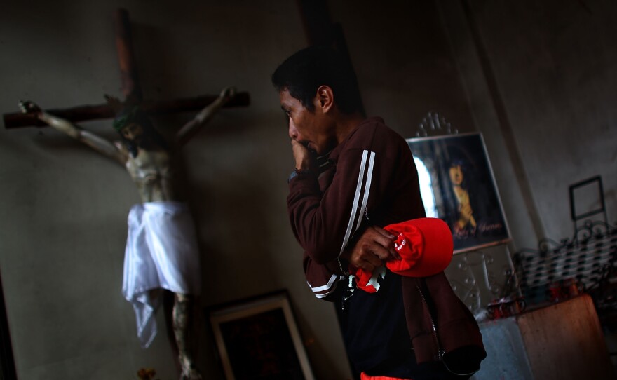 A Filipino man wipes the tears from his eyes on Sunday before morning Mass at Santo Nino church.