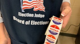 An election judge prepares to hand out "I voted" stickers during the March 2020 primary.