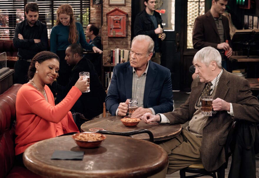 A Black woman holds up a glass of beer as two old white men look at her quizzically.