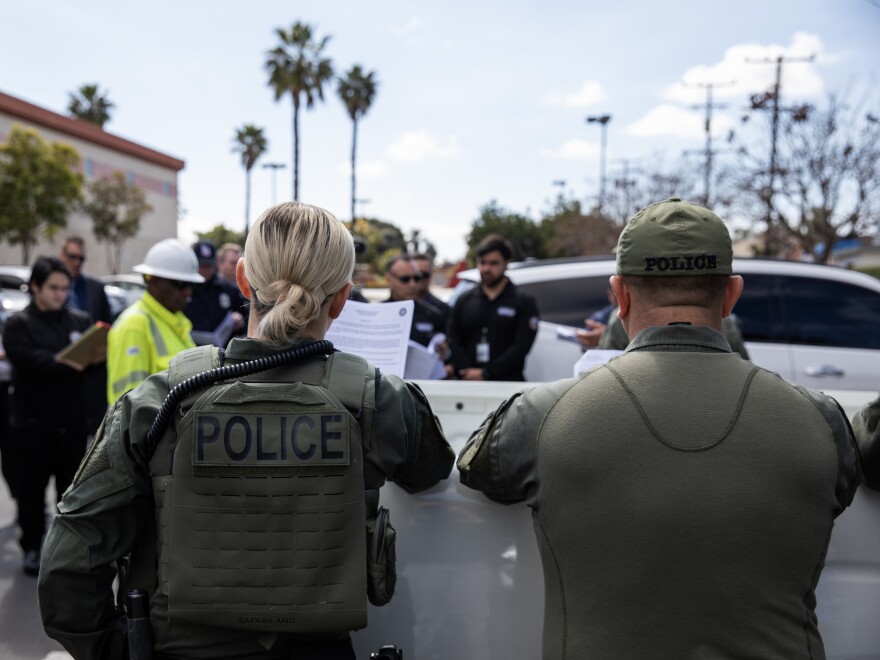 Department of Cannabis Control detectives, with Long Beach law enforcement, prepare to serve a search warrant on an unlicensed marijuana store in Long Beach, Calif., on March 5, 2024. Last year California's Cannabis Enforcement Taskforce served more than 300 search warrants on unlicensed operations in the state.