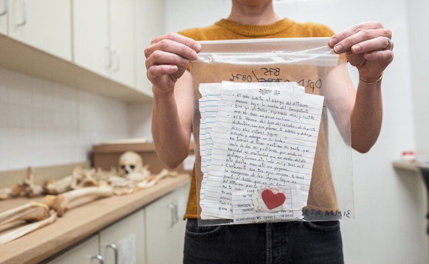 Anthropologist Kate Spradley holds up letters collected from immigrants who died while crossing the U.S.-Mexico border.