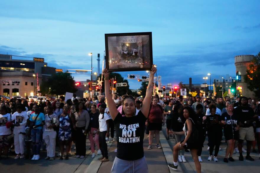 A protester holds a photo of Corey Durell Ruiz as they march Thursday, July 23, 2026, in Madison, Wis., after he was shot and killed by a Madison police officer on Wednesday.