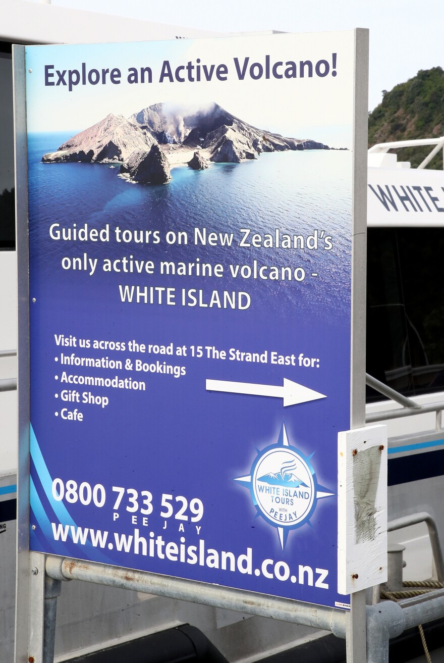 A sign at the Whakatane wharf advertises guided tours of the White Island volcano. Officials had recently released alerts warning that it was more active than usual.