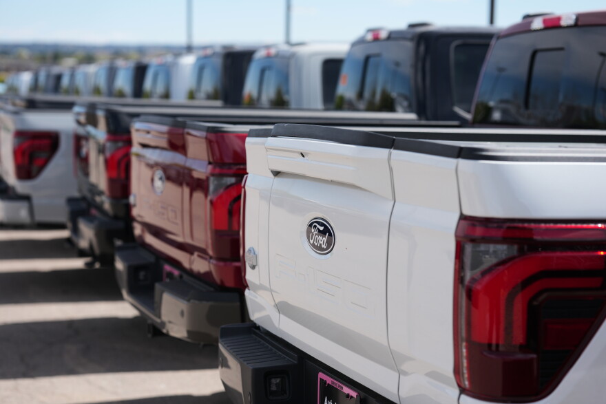 Unsold 2026 F-150 pickup trucks sit in a long line outside a Ford dealership on April 12, 2026, in Centennial, Colo.