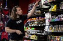 Cody Edwards, store manager at Smoke ATX on Austin's West Slaughter Lane, stocks shelves with smokable hemp products before state rules took effect.