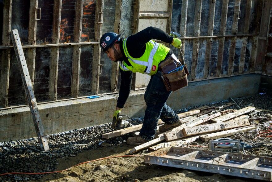 A construction worker builds formwork for the foundation of a residential building that will be part of Oak Grove - an affordable housing complex in Norwalk.