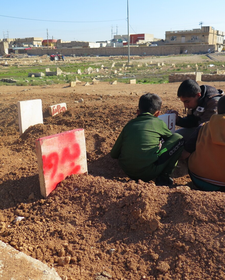 Neighborhood children reading gravestones. One is for Badawiya and Abed – a 15-year-old girl and her 6-year-old brother killed when their house collapsed during an airstrike in Mosul. She died with her arms around her little brother trying to protect him. Gravediggers said they couldn't pry them apart and buried them in the same grave.