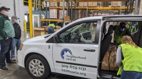 Volunteers load Thanksgiving meal kit donations from Hy-Vee into a Neighborhood House van at the Midwest Food Bank facility in North Peoria.  