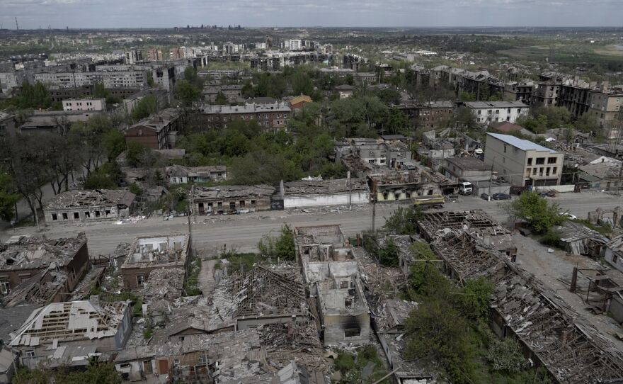 A shot of the city from high up shows destroyed buildings and debris.