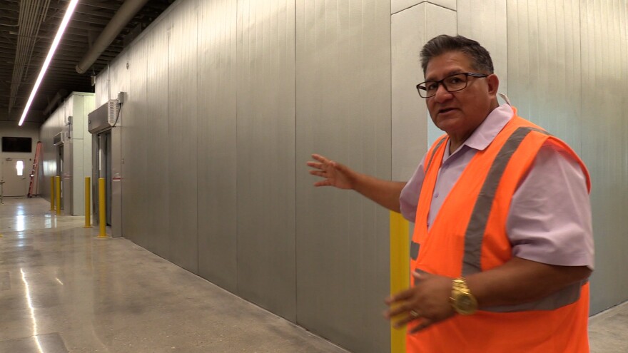 Lorenzo Alba, Jr. stands outside of a refrigeration unit at Casa de Peregrinos's new facility.