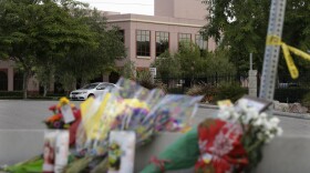 Flowers are placed on Sunday near the building where last week's shooting rampage took place at the Inland Regional Center in San Bernardino, Calif.