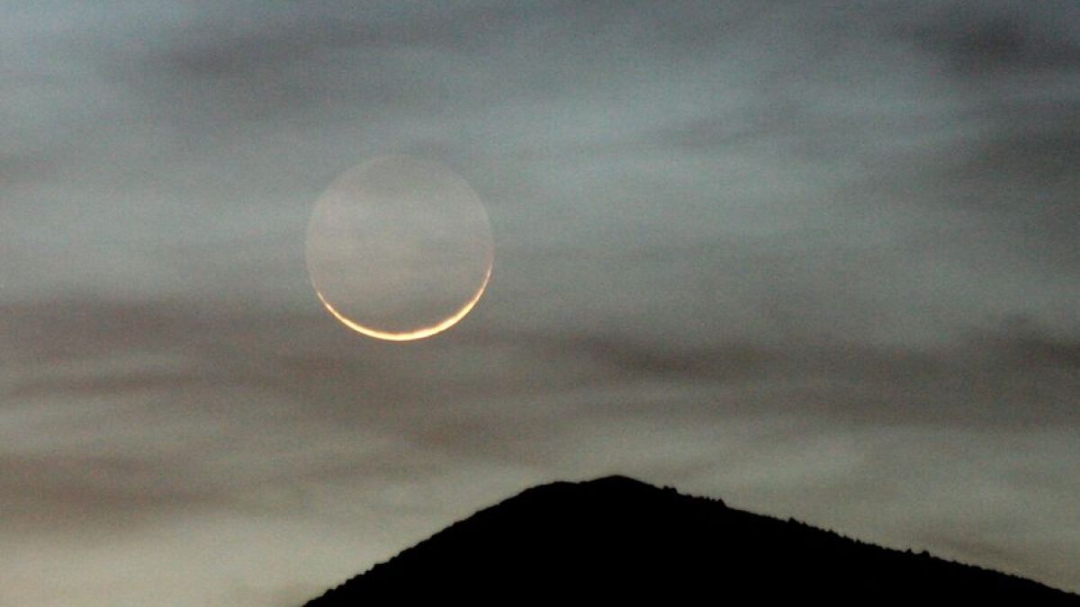 Crescent moon over a mountain
