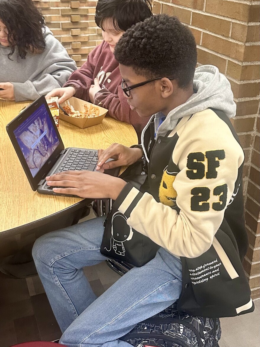 A YCS student works at his laptop.